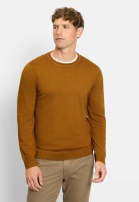 Senfgelber Rundhals-Pullover aus weichem Strickmaterial. Verfügt über lange Ärmel und ein dezentes geripptes Design an Saum und Kragen.