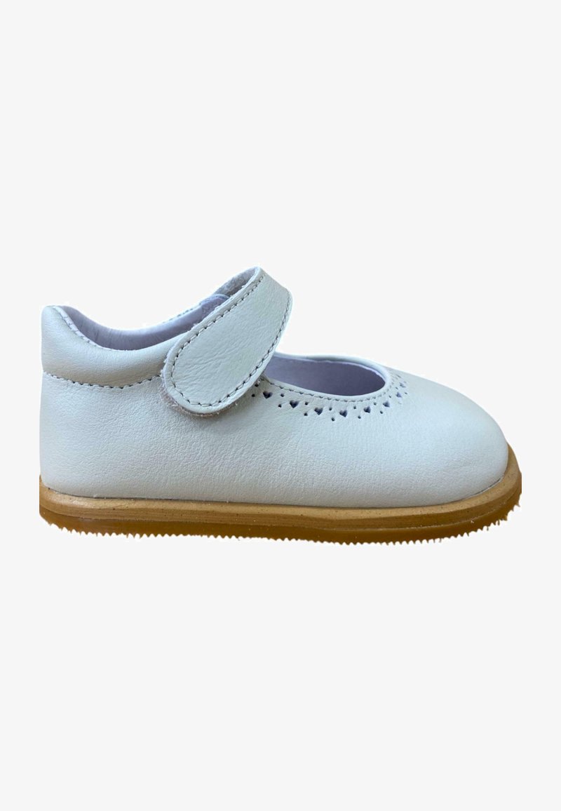 Zapato Mary Jane de cuero blanco con punta redondeada, correa ajustable de Velcro, detalle decorativo perforado y suela de goma marrón.