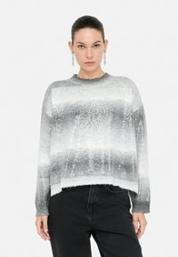 Pulover tricotat gri și alb cu un model în degradé, mâneci lungi și croială lejeră. Prezintă un guler rib și un material texturat.