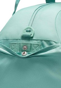 Mintgrønn bag med teksturert overflate, som har glidelås på toppen, en knappelukking og kontrasterende sømdetaljer.