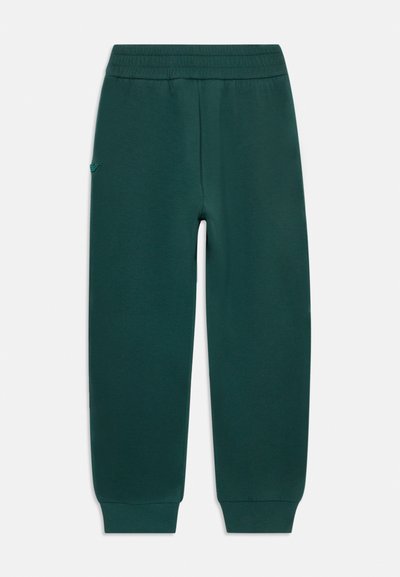 Mørkegrønne joggebukser med elastisk midje og mansjetter, med en liten logo på venstre lår, vist flatt på en hvit bakgrunn.