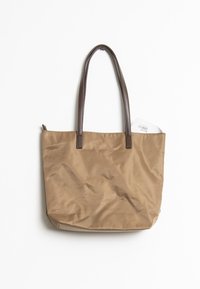 Borsa tote in nylon beige con texture liscia, manici in pelle marrone e apertura superiore senza chiusura. Contiene un'etichetta visibile che sporge dall'apertura.