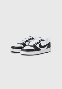 Sort og hvide sneakers med en syntetisk overdel, perforeret tåkap, snørelukning og hvid mellemsål. Har et fremtrædende sort logo.