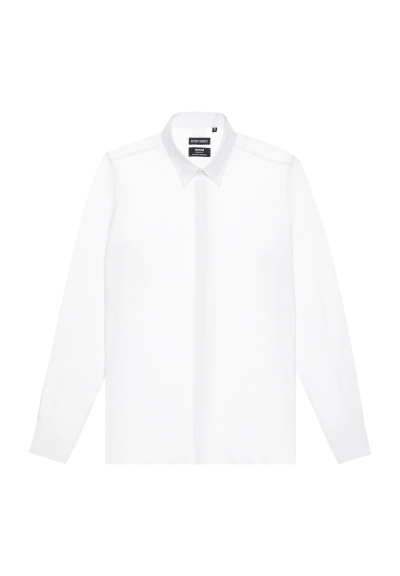 Camisa blanca de manga larga fabricada en una tela suave, con un cuello clásico y cierre de botones en el frente, con mangas con puños y un diseño ajustado.