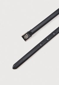 Črni usnjeni trak z gladko teksturo, opremljen s srebrnkastim kovinskim okrasjem in logotipi. Luknje za nastavljivo velikost vzdolž traku.