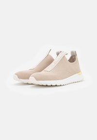 Sneakers slip-on beige con tomaia in rete, cinturino elasticizzato e suola bianca. Presentano un'inserzione dorata sul tallone e una superficie texturizzata.