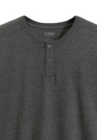 Ciemnoszara koszula typu henley z miękkiego materiału, z okrągłym dekoltem, dwiema guzikami i małym logo nadrukowanym na piersi.