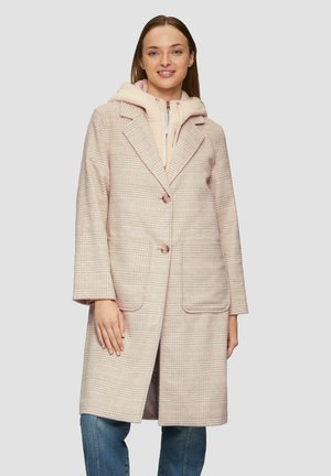 Manteau à carreaux rose clair avec une coupe décontractée, col à revers, deux poches avant et fermeture à boutons, superposé à un hoodie rose pâle.