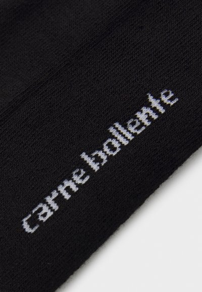 Melna adīta cepure ar baltu izšūtu tekstu "carne bollente" priekšpusē. Gluda tekstūra ar ciešu piegulšanu.