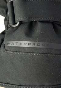 Zwarte waterdichte laars met een bovenwerk van gestructureerde stof, met een opvallend "WATERDICHT" label en een veilige riem. Gladde afwerking en duurzame ontwerp.