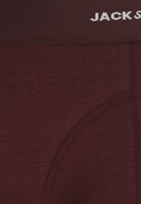 Culotte pour homme marron avec une texture de tissu douce, ceinture élastique avec "JACK" en lettres blanches, et un design de poche profilée.