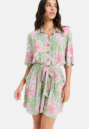 Robe chemise en tissu vert clair avec un imprimé floral rose et bleu, avec des boutons sur le devant, des manches courtes, une taille cintrée avec une ceinture à nouer, au design décontracté.