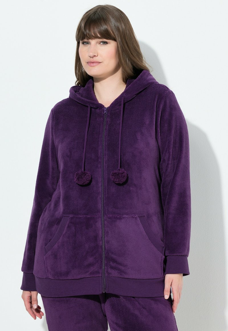 Haut de hoodie zippé en polaire violet avec capuche, poches avant et cordons avec pompons. Texture douce avec des poignets et un ourlet côtelés.