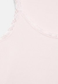 Tissu côtelé rose clair avec une délicate bordure en dentelle le long d'un bord incurvé, probablement partie de l'encolure ou d'une manche d'un vêtement.
