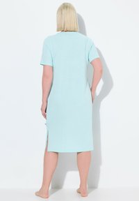 Camicia da notte in cotone azzurro chiaro, con maniche corte, lunghezza a metà polpaccio, fessure laterali e un design semplice. Nessun motivo o accessorio visibile.