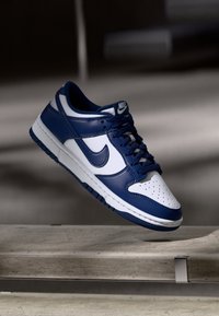 Nike Dunk Low kengät sisältävät tummansinisen ja valkoisen nahkapinnan, rei'itetyn varvaskohdan ja teksturoidun kumipohjan matalassa leikkausmuodossa.