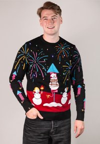 Schwarzer Pullover mit mehrfarbigen, festlichen Designs, darunter Schneemänner, Feuerwerke und ein Schornstein mit blauem Dach.