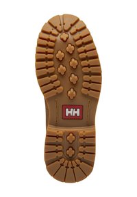 Suela de zapato de goma con una combinación de colores marrón y beige. Presenta patrones texturizados con nódulos de tracción y un logo de marca en rojo y blanco.