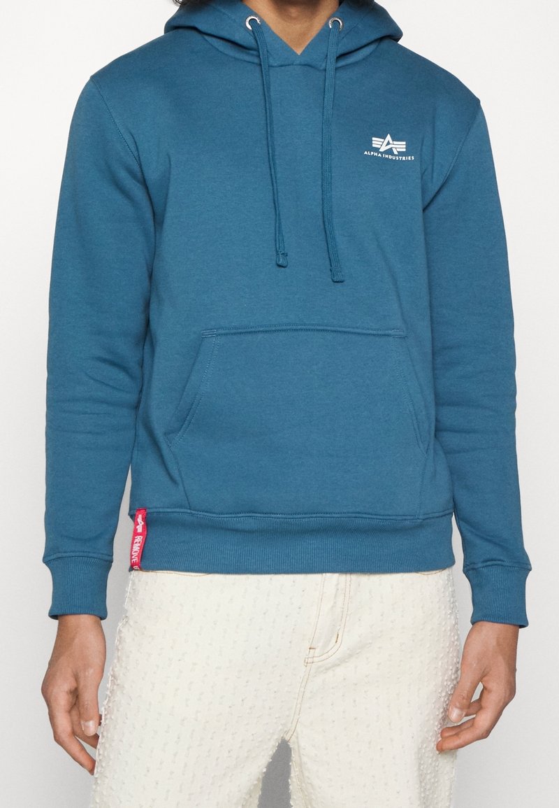 Felpa con cappuccio blu in cotone, con tasca a marsupio, cappuccio con coulisse e piccolo logo bianco sul petto. Dettaglio con etichetta rossa sull'orlo.