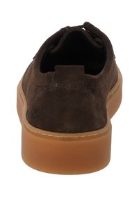 Scarpa in suede marrone con punta tonda, suola in gomma e tacco basso. Include dettagli di cucitura e una linguetta ad anello sul retro.