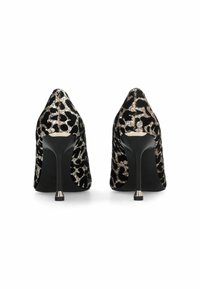Escarpins à talon aigu en imprimé léopard noir et or, en matériau texturé, avec un talon fin et un accent métallique.