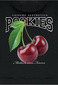 Felpa nera con un grafico di due ciliegie rosse lucide con foglie verdi e il testo "POOKIES" sopra e "Mediocre da sempre" sotto.