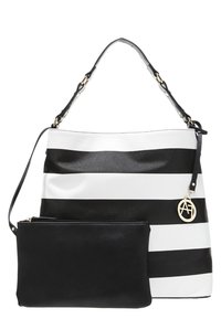Sac à main à rayures horizontales noires et blanches avec une pochette noire détachable et un porte-clés logo circulaire en métal doré.
