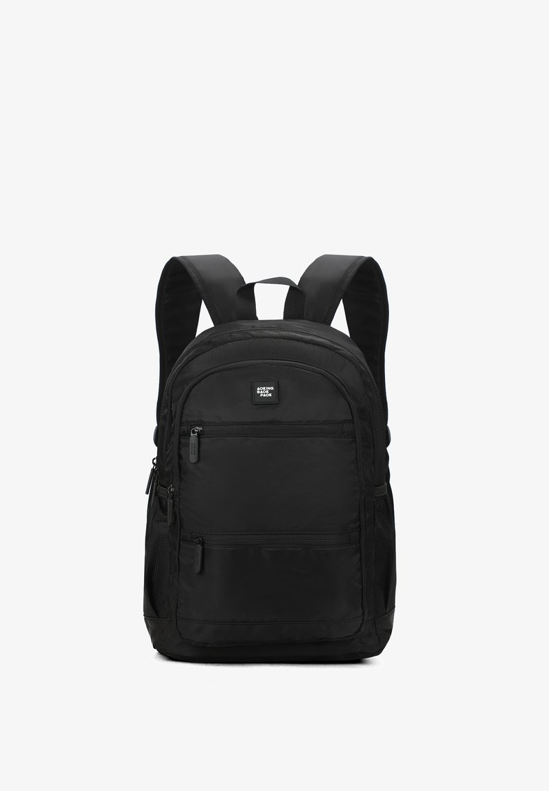 Sac à dos noir avec des bretelles rembourrées, une poche zippée à l'avant, des poches latérales en mesh et une surface en tissu lisse et durable.