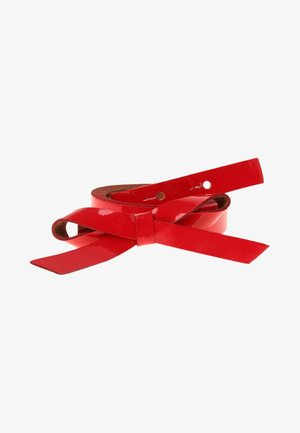 Ceinture en cuir rouge brillant enroulée avec un nœud simple et deux trous visibles sur un fond blanc.