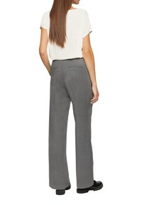 Pantalons gris à jambes larges en tissu texturé, avec deux poches arrière et un design avec pinces. Associés à un haut blanc uni à manches courtes.
