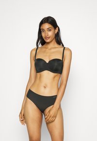 Črn podložen modrček z nastavljivimi naramnicami in gladkim zaključkom iz tkanine, v kombinaciji z nedrčkimi bikini hlačkami brez šivov, ki vsebujejo detajl z logotipom.