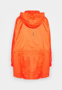 Veste de pluie à capuche orange vif avec poignets et taille élastiques, doublure en mesh dans la capuche et texte vertical réfléchissant dans le dos.