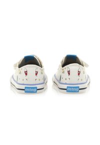Scarpe da tela bianche con un accento blu e motivi giocosi a tema spaziale, che presentano stelle e razzi, con una suola in gomma piatta.