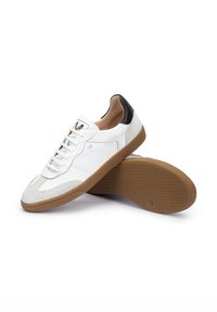Witte leren sneakers met een suede neus, zwarte hakaccenten en een gumrubberen zool. Voorzien van witte veters en een merklogo op de tong.