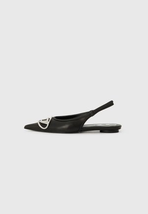 Black pointed-toe slingback shoe with a flat heel and a metallic logo accent on the front. Made of smooth leather with a sleek finish.