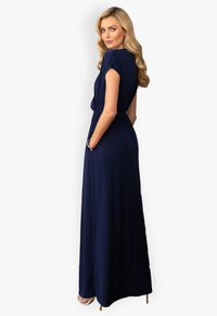Navyblaues Maxikleid mit kurzen Ärmeln, geraffter Taille und Seitentaschen. Glattes Material und bodenlanger Schnitt. Einfach und elegant.