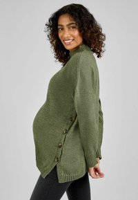 Maglione verde oliva con colletto a costine e bottoni laterali, caratterizzato da una vestibilità rilassata e un orlo inclinato. Tessuto morbido e maniche lunghe.