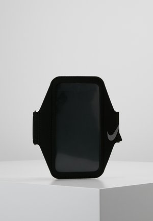 Black smartphone armband with clear screen window. Made of stretchable fabric, featuring a silver Nike logo and adjustable strap.