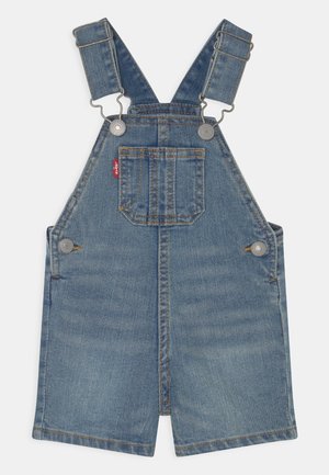 Peto de mezclilla azul para niños pequeños con tirantes ajustables, bolsillo frontal en el pecho, botones laterales y una pequeña etiqueta roja con el logo de Levi's en la costura del bolsillo.