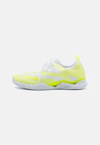 Scarpa atletica bianca con tomaia a motivo giallo e grigio, design con lacci e suola texturizzata. Presenta un'etichetta di estrazione e un marchio sul lato.