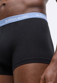 Μαύρα βαμβακερά μποξεράκια με ελαφρώς μπλε λάστιχο στη μέση που φέρει το λογότυπο "BJÖRN BORG". Λείο υλικό, εφαρμοστή σχεδίαση, χωρίς ορατά μοτίβα.