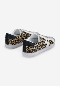 Leopard print sneakers with black leather accents, white laces, and a textured gray sole. Low-top design with a rounded toe.
