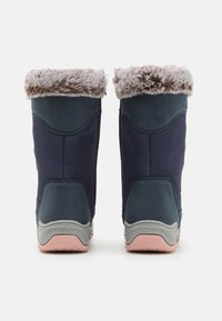 Bottes de marine avec un col en fourrure douce gris et des côtés texturés. Semelle en caoutchouc rose et gris, avec un design courbé et des matériaux stratifiés.