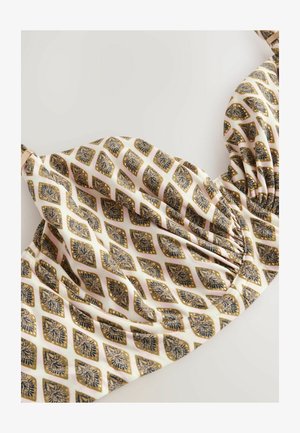 Tryckt bikinitopp med en krämfärgad bakgrund och mörkblå och gyllene diamantskårade mönster samt en samlad detalj i mitten.