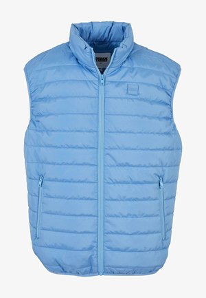 Világoskék, puffasztott mellény magas gallérral, vízszintes tűzéssel, elöl cipzárral, és két oldalsó cipzáros zsebbel.