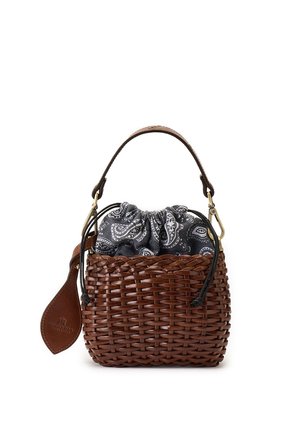 Piccola borsa marrone intrecciata con manico singolo, sacchetto interno con coulisse in tessuto paisley bianco e nero e etichetta di pelle attaccata al lato.