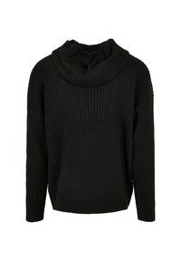 Pull en maille noire avec un col montant à capuche. Présente une texture côtelée et une coupe ample, avec des épaules légèrement tombantes et des manches longues.