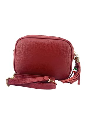Sac bandoulière en cuir rouge avec surface texturée, quincaillerie dorée, fermeture éclair et un pompon décoratif. Sangle réglable incluse.