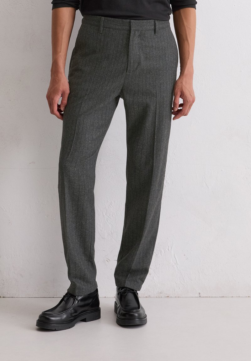 Grijze gestreepte broek van een gestructureerde stof, met een slim fit en een platte voorkant, gecombineerd met zwarte veterschoenen.