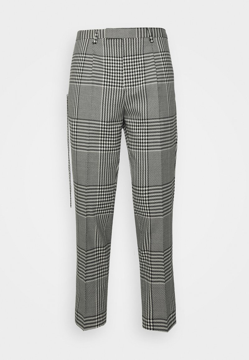 Pantalon à carreaux noirs et blancs présentant un large motif à carreaux, des jambes fuselées, des passants de ceinture et des poches latérales avec une finition texturée.